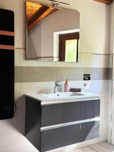 a bathroom with a sink and a mirror at Casa vacanze Adri in Faggeto Lario 