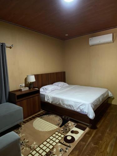 a bedroom with a bed and a table and a couch at Han's Villa in Sumbawa Besar