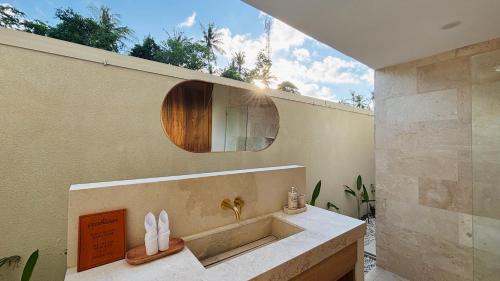 a bathroom with a sink and a mirror on the wall at Oasis Dune Villas Lombok in Kuta Lombok