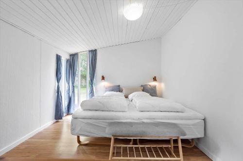 a bed in a white room with a window at 1102-Stege-Rylevej-24 in Stege