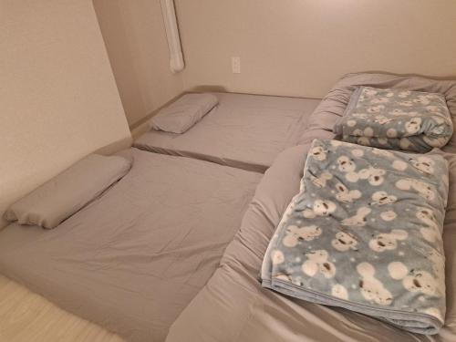 two twin beds in a room with at お部屋に露天風呂 自分専用の湯船に新鮮な熱海温泉を入れる贅沢 新築美麗AtamiOnsenApart104 in Atami