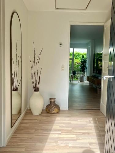 a hallway with two large vases on the floor at Spacious Luxury Villa in Copenhagen in Copenhagen