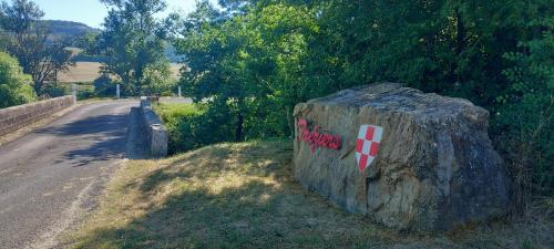 a rock with a cross painted on it on the side of a road at Au Repos in Tréziers