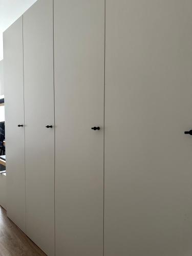 a row of white cabinets in a room at Century hostel in Gdynia