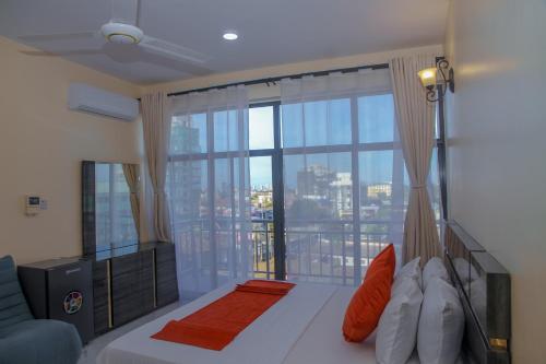 a bedroom with a bed and a large window at Andrew View Hotel in Dar es Salaam