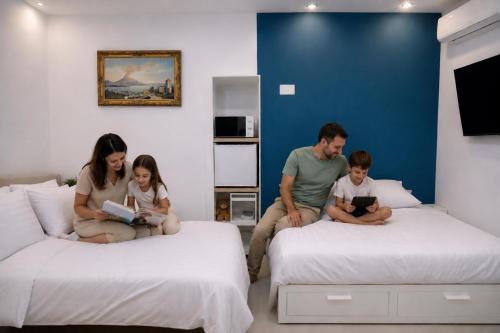 a family sitting on two beds reading books at Casa Schiattarella Napoli in Naples