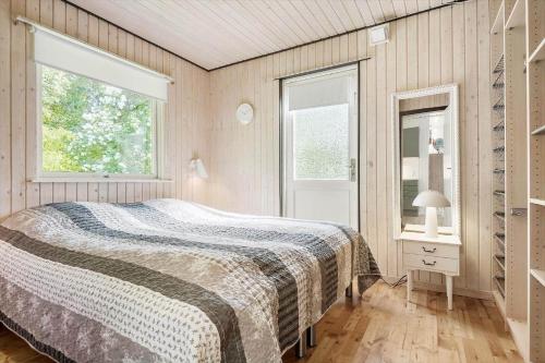 a bedroom with a bed and two windows at 8229-Lundby-Stenurtvej-6 in Lundby