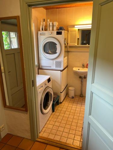 a small bathroom with a washing machine and a washer at Mariehem Logi in Sjöbo