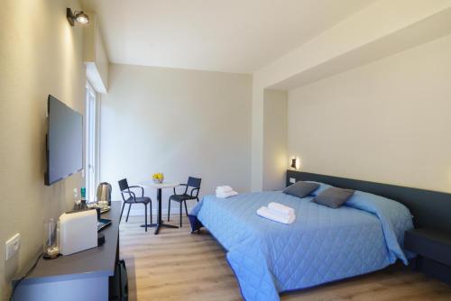 a bedroom with a blue bed and a table with chairs at Respiro di Mare in Riomaggiore