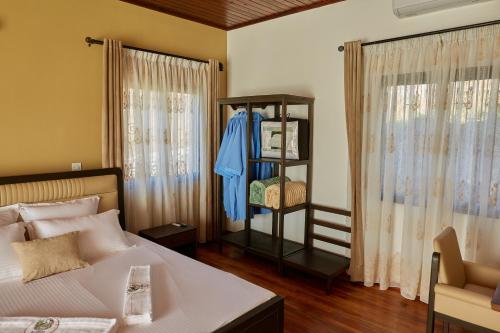 a bedroom with a bed and a shelf with clothes at Echoes of forest in Andasibe