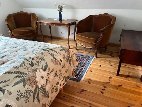 a bedroom with two chairs and a bed and a table at Mariehem Logi in Sjöbo