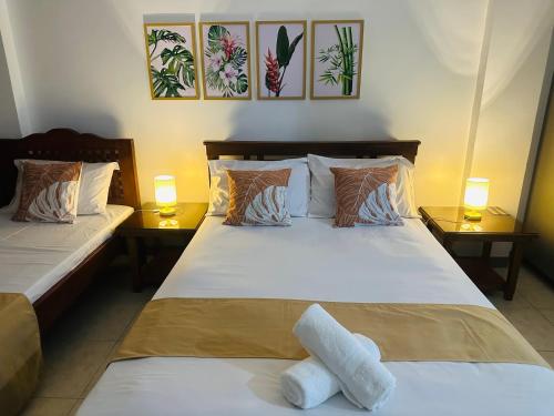 a bedroom with two beds and two lamps on tables at JORA Studio Apartment 1-B in Dagupan