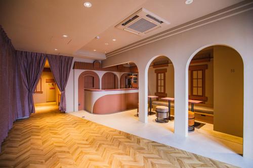 a room with a wooden floor and purple curtains at SABLIER by R HOTEL in Osaka