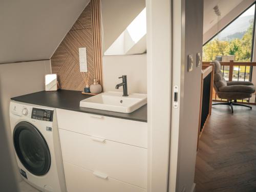 a bathroom with a sink and a washing machine at Miło Tu - Stodoła pod Karpaczem in Miłków