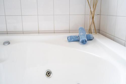 a bathroom with a tub with blue towels on the floor at Spa Hotel Kasnäs in Kasnäs