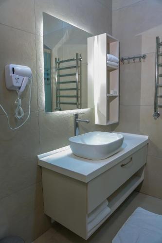 a bathroom with a white sink and a mirror at Chukhur Gabala Museum Hotel in Gabala