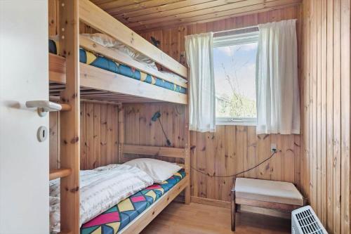 a bedroom with bunk beds in a wooden cabin at FA058-Faxe-Ladeplads-Anders-Lassens-vej-2 in Fakse Ladeplads