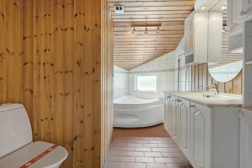 a bathroom with a tub and a toilet and a sink at FA058-Faxe-Ladeplads-Anders-Lassens-vej-2 in Fakse Ladeplads