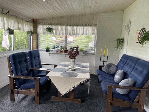 a dining room with a table and two blue chairs at Zuzanna in Storebro