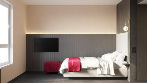 a bedroom with a bed and a tv on a wall at PLAZA Residence Mannheim in Mannheim