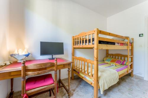 a bedroom with two bunk beds and a desk at La Villa D'antan - Piscine in Nyons