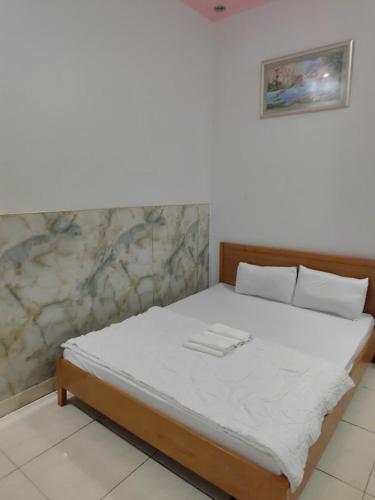 a bed in a room with a white mattress at Khách Sạn Lâm Tiên - Lam Tien Hotel in Bùi Tiếng
