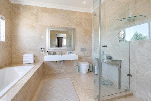 a bathroom with a tub and a sink and a shower at Vetho Villa in Cape Town