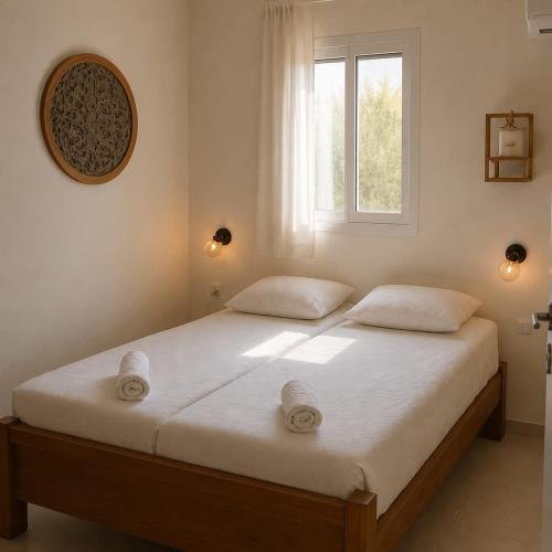 a bedroom with a bed with white sheets and a window at The corner in Sde Ilan in Sede Ilan