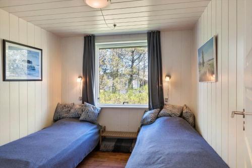 a bedroom with two beds in front of a window at 1352-Vestervig-Isfuglevej-19 in Vestervig