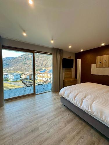 a bedroom with a large bed and a large window at Hotel Almazzago in Commezzadura