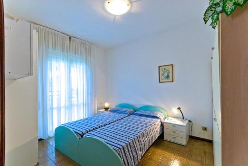 a bedroom with a blue bed and a window at Luca in Bibione