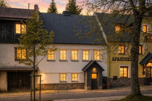 a white house with a black roof at Chata Ve Stopě in Boží Dar
