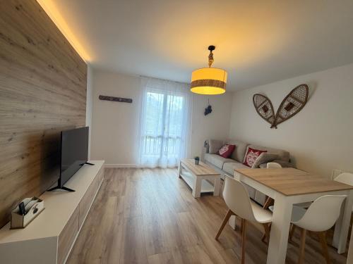 a living room with a table and a couch at Apartamentos Leyre Candanchú in Candanchú