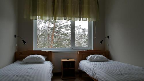 two twin beds in a room with a window at Männiku JK in Tallinn