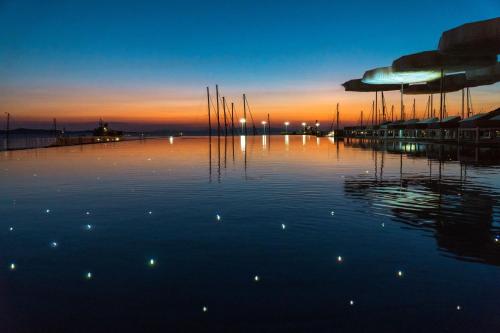 a view of a marina at sunset with boats in the water at Mykonos Riviera Hotel & Spa, a member of Small Luxury Hotels of the World in Tourlos