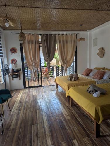 a bedroom with two beds and a wooden floor at Maison PAYAPA PORT BARTON in San Vicente