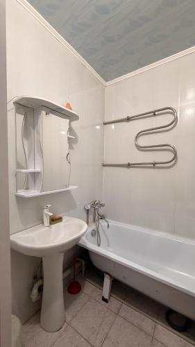 a white bathroom with a sink and a tub and a toilet at Квартира Алимжанова 16 Балхаш in Balqash