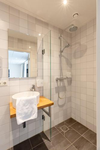 a bathroom with a sink and a shower at De Zwaan Delden in Delden