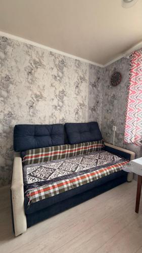 a bed in a room with a blue couch at Квартира Алимжанова 16 Балхаш in Balqash