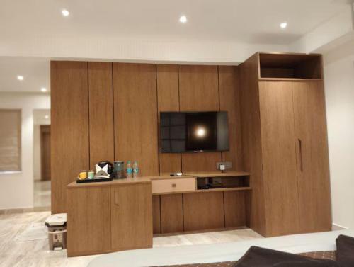a living room with a tv on a wooden wall at Eennra Ssubarna in Baharampur