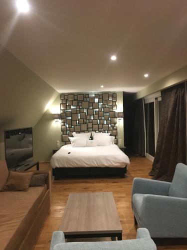 a large bedroom with a bed and a couch at De Gouden Klokke in Avelgem