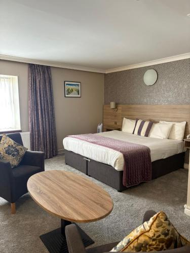 a hotel room with a bed and a table at Treacys West County Conference and Leisure Centre in Ennis