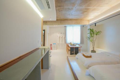 a large room with two beds and a desk and a table at 스테이머묾 m2 in Jeonju