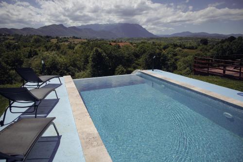 a swimming pool with chairs and a view of the mountains at SkyAtlas Hideaway in Sohodol