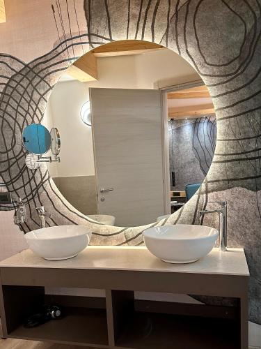 a bathroom with two sinks in front of a mirror at Hotel Almazzago in Commezzadura