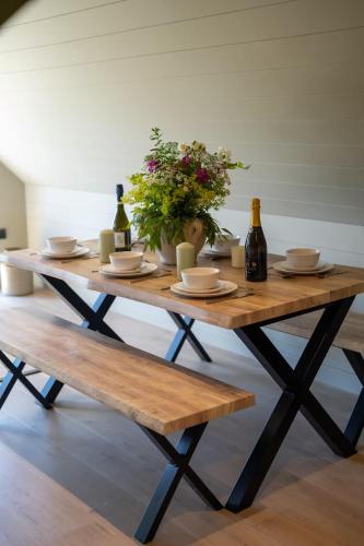 a wooden table with two bottles of wine and flowers at The Stable in Clack