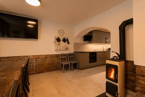 a kitchen and living room with a wood stove at Chata Ve Stopě in Boží Dar