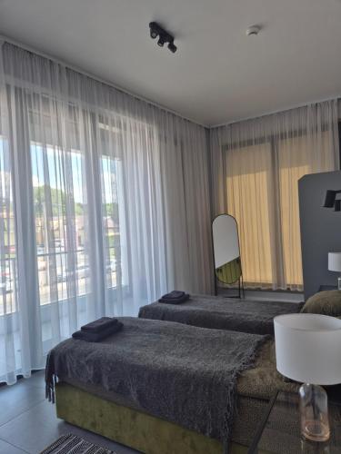a bedroom with two beds and a chair and windows at APARTAMENTY PRUCHNICKA in Jarosław