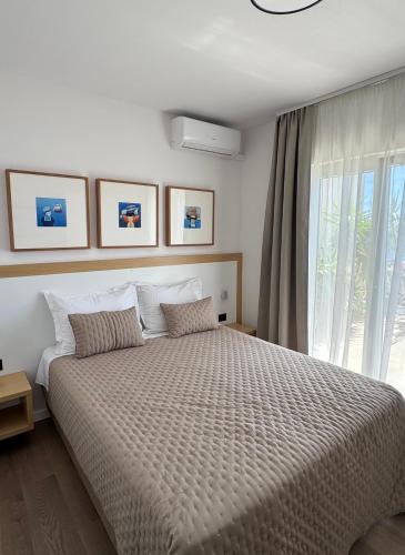 a bedroom with a large bed with a large window at Villa Nora in Tučepi