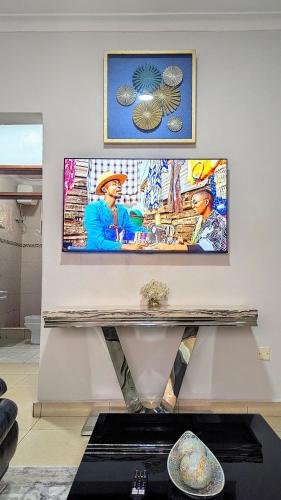 a table in a room with a painting on the wall at Vine Vale in Kampala